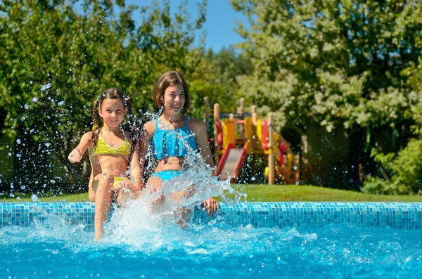 I bambini in piscina si divertono e schizzano in acqua, i bambini in vacanza in famiglia — Foto Stock