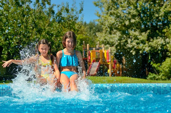 Les enfants dans la piscine s'amusent et éclaboussent dans l'eau, les enfants en vacances en famille — Photo