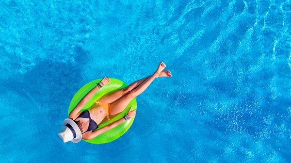 美しい女性で帽子でプールの空中ビュー上から 若い女の子リラックスし 休暇中に水の中でインフレータブルリングを楽しんで — ストック写真