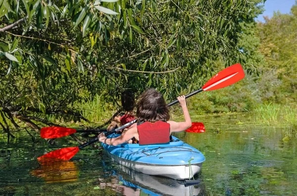 Family kayaking, mother and child paddling in kayak on river canoe tour, active summer weekend and vacation, sport and fitness concept