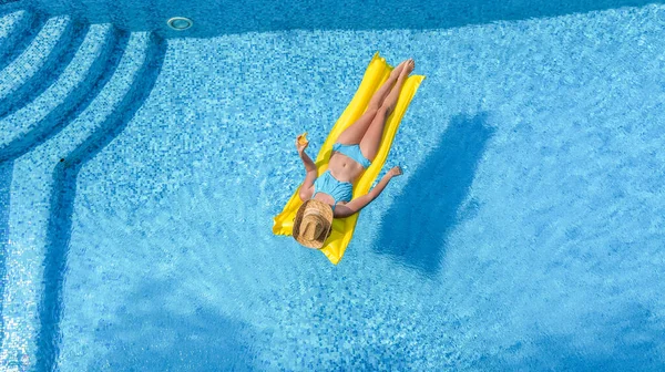 아름다운 수영장에서 휴식을 취하고 여자가 푹신푹신 매트리스를 수영을 물에서 재미를 — 스톡 사진