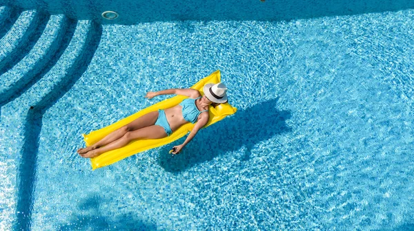 スイミングプールでリラックスした美しい若い女の子 女性はインフレータブルマットレスで泳ぐと家族の休暇に水の中で楽しみを持っています トロピカルホリデーリゾート 上から空中ドローンビュー — ストック写真