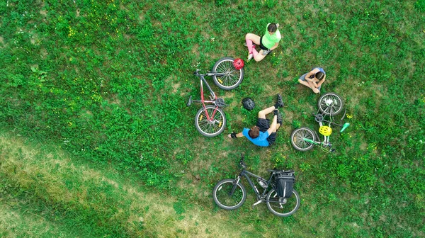 骑自行车的家庭骑自行车从空中观看 快乐活跃的父母抱着孩子 周末在草地 家庭运动和健身上玩得开心和放松 — 图库照片