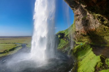 İzlanda 'da güzel Seljalandsfoss şelalesi, İzlanda yaz doğası ve nehir manzarası