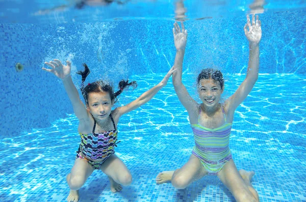 Fröhliche aktive Kinder schwimmen im Pool und spielen unter Wasser — Stockfoto