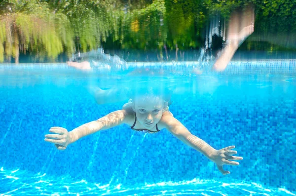 Criança nada na piscina, brincando e se divertindo, subaquático e acima da vista — Fotografia de Stock