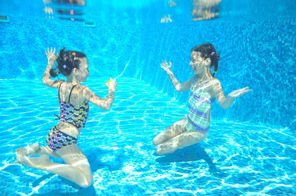 Crianças ativas felizes nadam na piscina e brincam debaixo d 'água — Fotografia de Stock