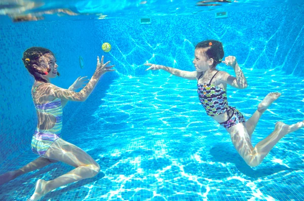 Crianças ativas felizes nadam na piscina e brincam debaixo d 'água — Fotografia de Stock