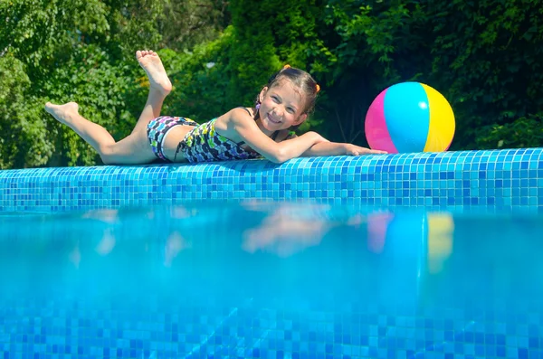 Bambina rilassante vicino alla piscina, sott'acqua e sopra la vista — Foto Stock