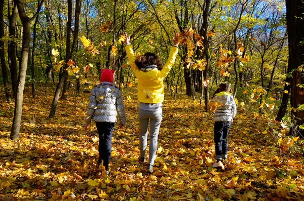 Lycklig familj som roar sig i höstskogen — Stockfoto