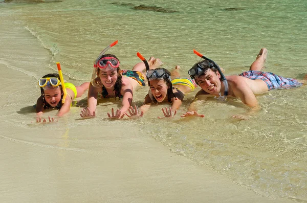 Boldog család snorkels trópusi tengerparton, nyaralás — Stock Fotó