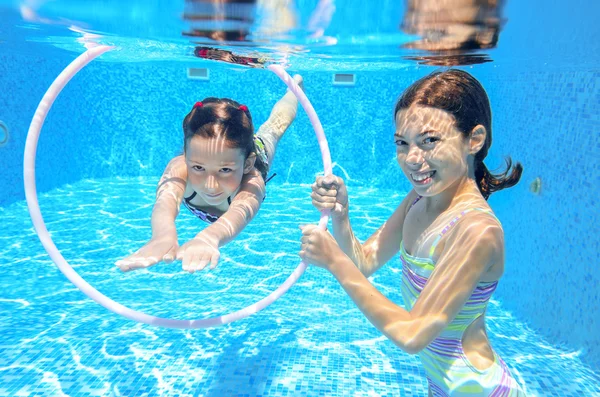 Kids swim in pool underwater, girls swimming — Stock Photo, Image