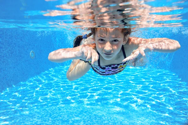 Menina feliz nada na piscina subaquática, criança ativa nadando — Fotografia de Stock