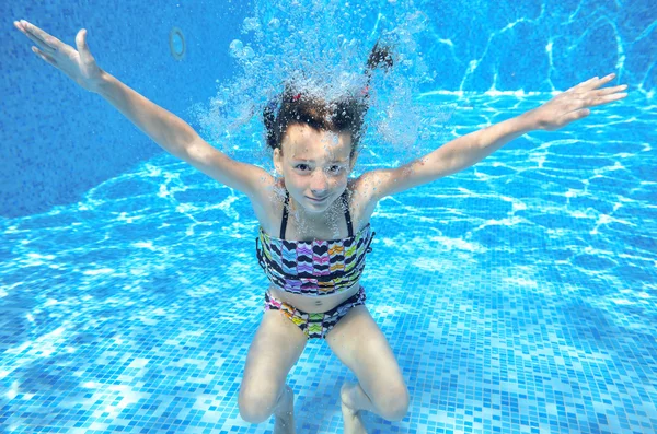 Menina feliz nada na piscina subaquática, criança ativa nadando — Fotografia de Stock