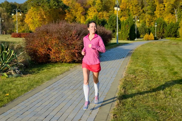 Mulher correndo no parque de outono, linda menina corredor correndo ao ar livre — Fotografia de Stock