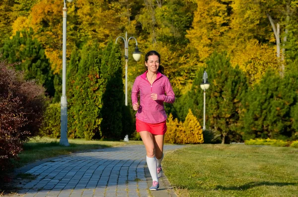 Женщина, бегущая в осеннем парке, красивая бегунья на свежем воздухе — стоковое фото