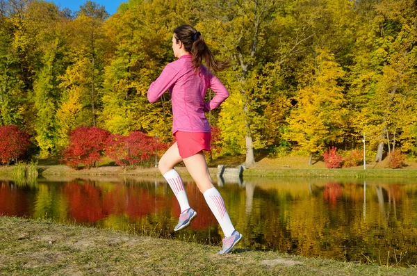 Femme en cours d'exécution dans le parc d'automne, belle fille coureuse jogging extérieur — Photo