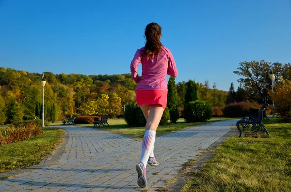 Woman running in autumn park, beautiful girl runner jogging outdoors — Stock Photo, Image
