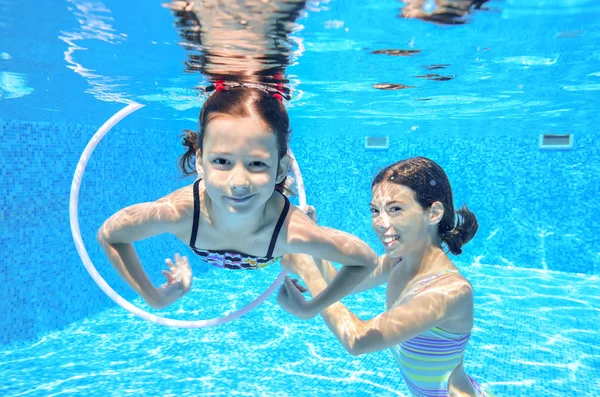 Niños felices nadan en la piscina bajo el agua, niñas nadando —  Fotos de Stock