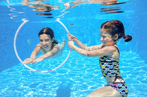 Happy children swim in pool underwater, girls swimming — Stock Photo, Image