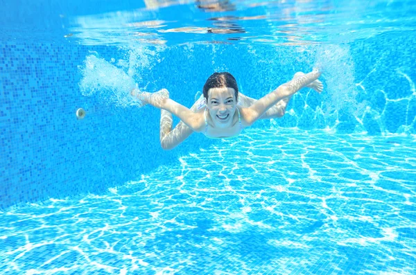 Chica feliz nada en la piscina bajo el agua, niño activo nadando —  Fotos de Stock