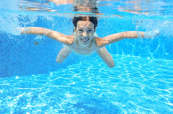 Menina feliz nada na piscina subaquática, criança ativa nadando — Fotografia de Stock