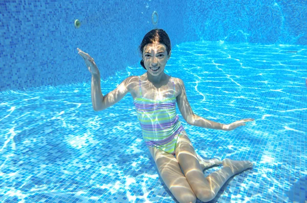 Chica feliz nada en la piscina bajo el agua, niño activo nadando — Foto de Stock