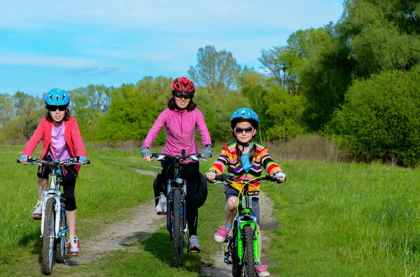 Happy mother and kids on bikes cycling outdoors, active family sport — Stock Photo, Image