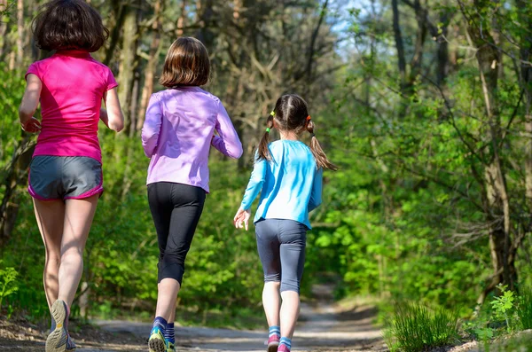 Familjen sport, glada aktiva mor och barn jogga utomhus, med i skogen — Stockfoto