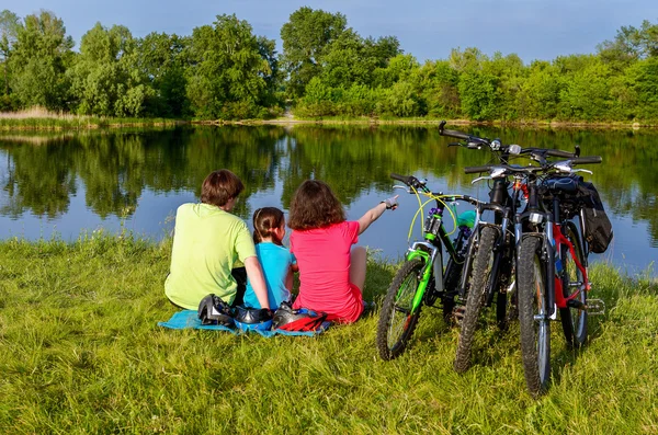Passeio de bicicleta familiar ao ar livre, pais ativos e criança pedalar e relaxar perto de belo rio — Fotografia de Stock