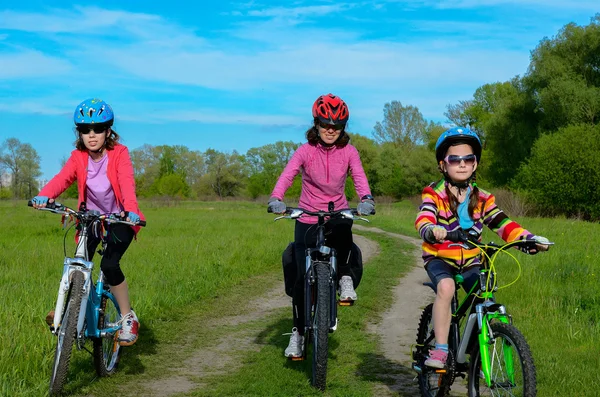 Happy mother and kids on bikes cycling outdoors, active family sport — Stock Photo, Image