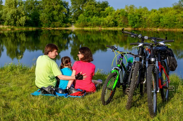 家族自転車乗るアウトドア、アクティブな親と子供のサイクリング、美しい川の近くリラックス — ストック写真