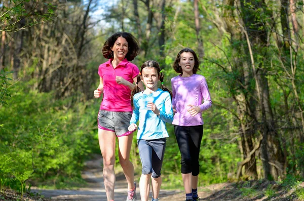 Aile spor, mutlu etkin anne ve açık havada jogging, ormanda koşu çocuklar — Stok fotoğraf