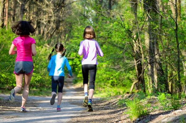 Familiesport, gelukkig actieve moeder en kinderen joggen buiten, die in bos loopt — Stockfoto