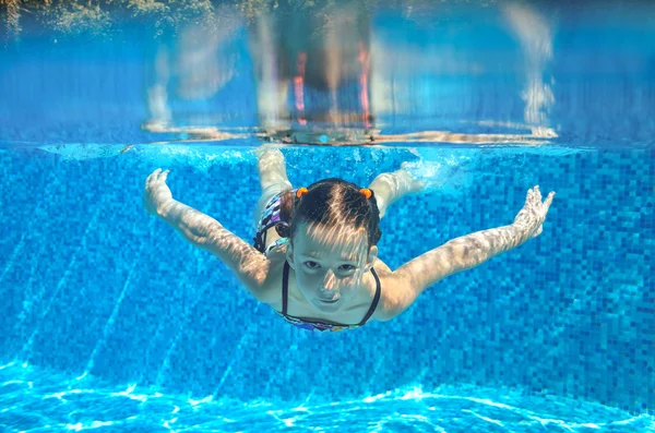 Menina feliz nada na piscina subaquática, criança ativa nadando, brincando e se divertindo, crianças esporte aquático — Fotografia de Stock