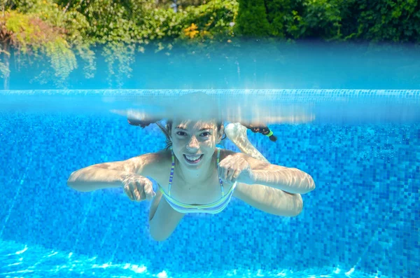 Happy girl swims in pool underwater, active kid swimming, playing and having fun, children water sport — Stock Photo, Image