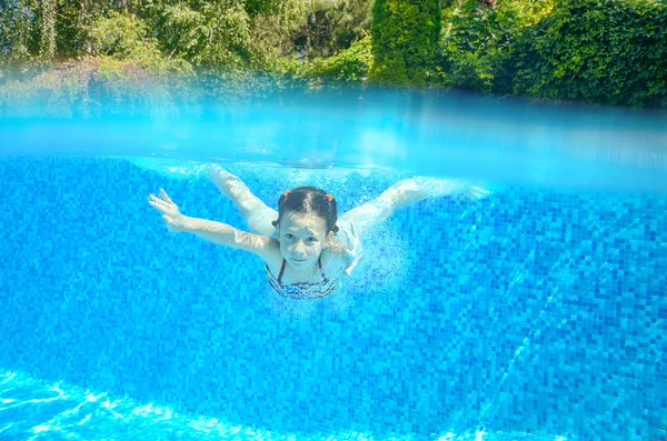 Menina feliz nada na piscina subaquática, criança ativa nadando, brincando e se divertindo, crianças esporte aquático — Fotografia de Stock