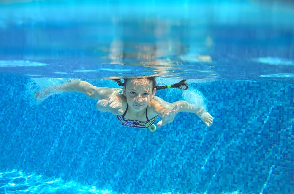 Chica feliz nada en la piscina bajo el agua, niño activo nadando, jugando y divirtiéndose, los niños deportes acuáticos —  Fotos de Stock