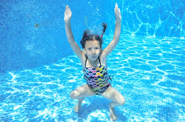 Menina feliz nada na piscina subaquática, criança ativa nadando, brincando e se divertindo, crianças esporte aquático — Fotografia de Stock