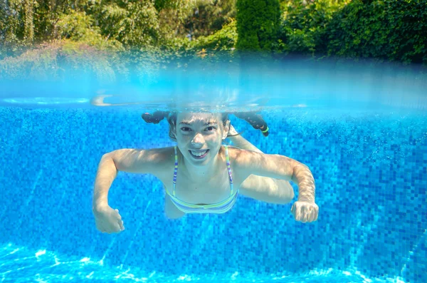 Happy girl swims in pool underwater, active kid swimming, playing and having fun, children water sport — Stock Photo, Image
