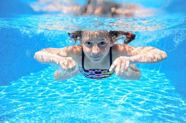 Menina feliz nada na piscina subaquática, criança ativa nadando, brincando e se divertindo, crianças esporte aquático — Fotografia de Stock