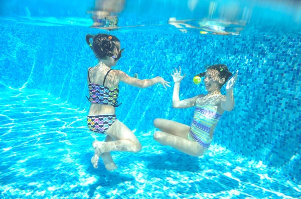 Crianças felizes nadam na piscina subaquática, meninas nadando, brincando e se divertindo, crianças esporte aquático — Fotografia de Stock