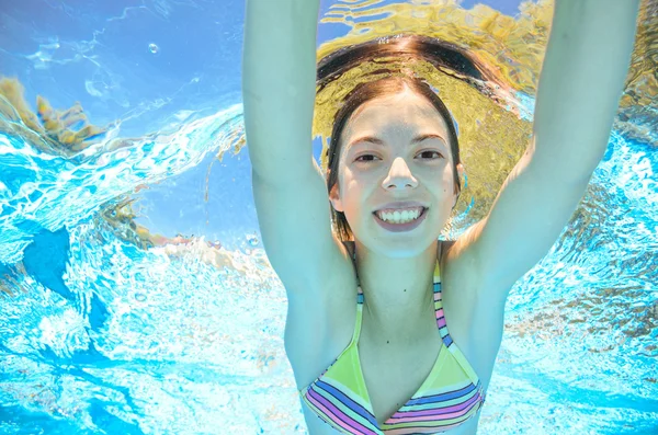 Child swims in pool underwater, happy active girl has fun in water, kid sport on family vacation — Stock Photo, Image