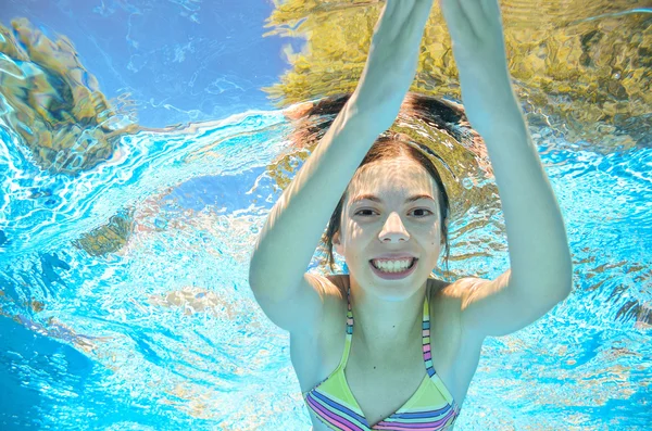 Child swims in pool underwater, happy active girl has fun in water, kid sport on family vacation — Stock Photo, Image