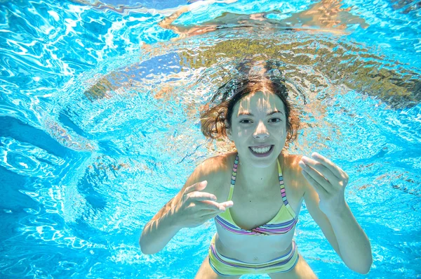 Kind schwimmt im Pool unter Wasser, fröhliches aktives Mädchen hat Spaß im Wasser, Kindersport im Familienurlaub — Stockfoto