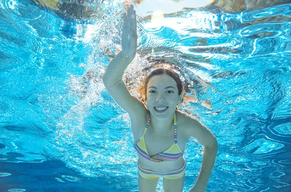 Child swims in pool underwater, happy active girl has fun in water, kid sport on family vacation — Stock Photo, Image