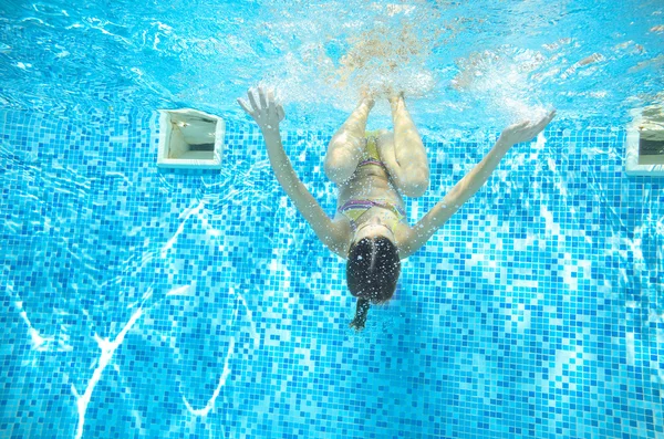 Dziecko pływa w basenie pod wodą, szczęśliwy, że aktywna dziewczyna ma zabawy w wodzie, sport dziecko na rodzinne wakacje — Zdjęcie stockowe
