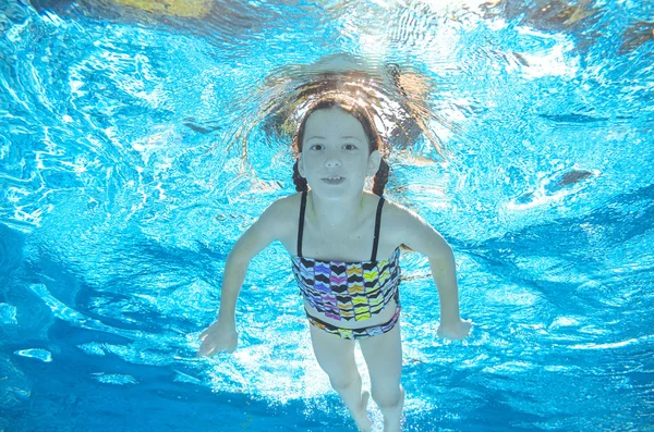 Dziecko pływa w basenie pod wodą, szczęśliwy, że aktywna dziewczyna ma zabawy w wodzie, sport dziecko na rodzinne wakacje — Zdjęcie stockowe