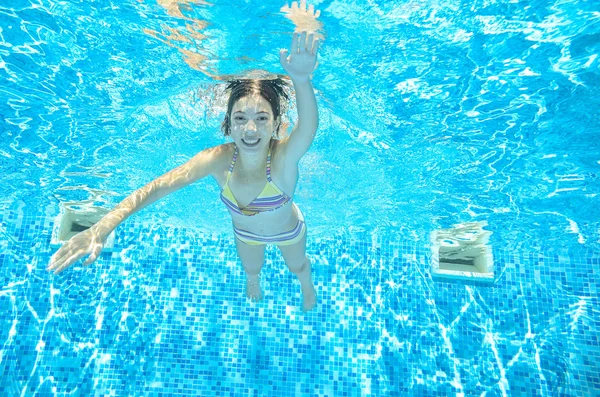 Criança nada na piscina subaquática, menina ativa feliz se diverte na água, esporte infantil em férias em família — Fotografia de Stock