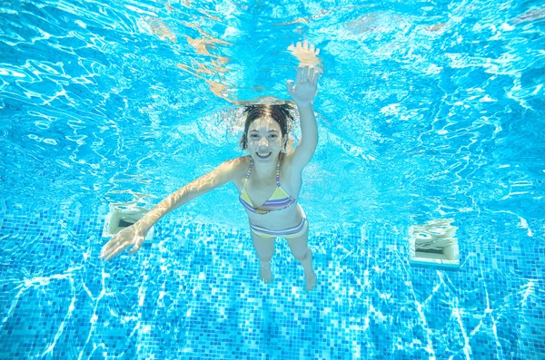 Kind zwemt in het zwembad onderwater, gelukkig actieve meisje heeft plezier in water, jongen sport op familie vakantie — Stockfoto